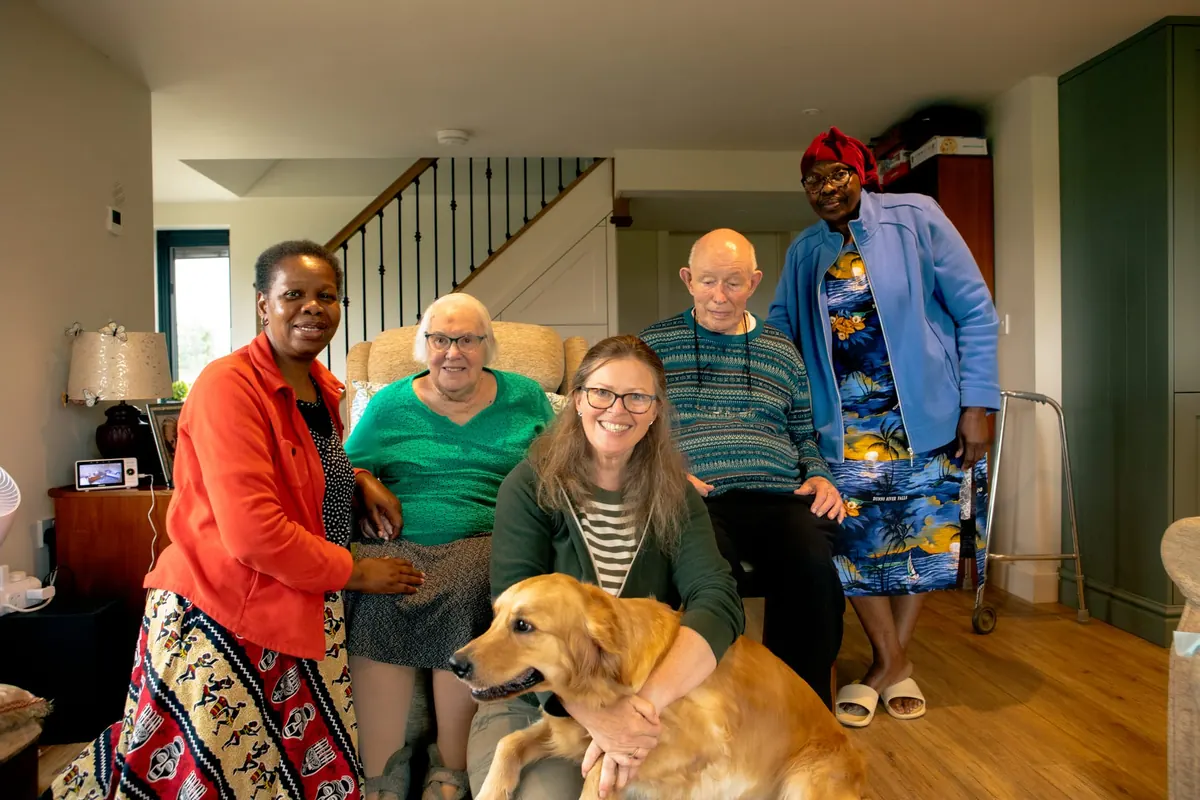 A carer supporting an older person in a comfortable home setting